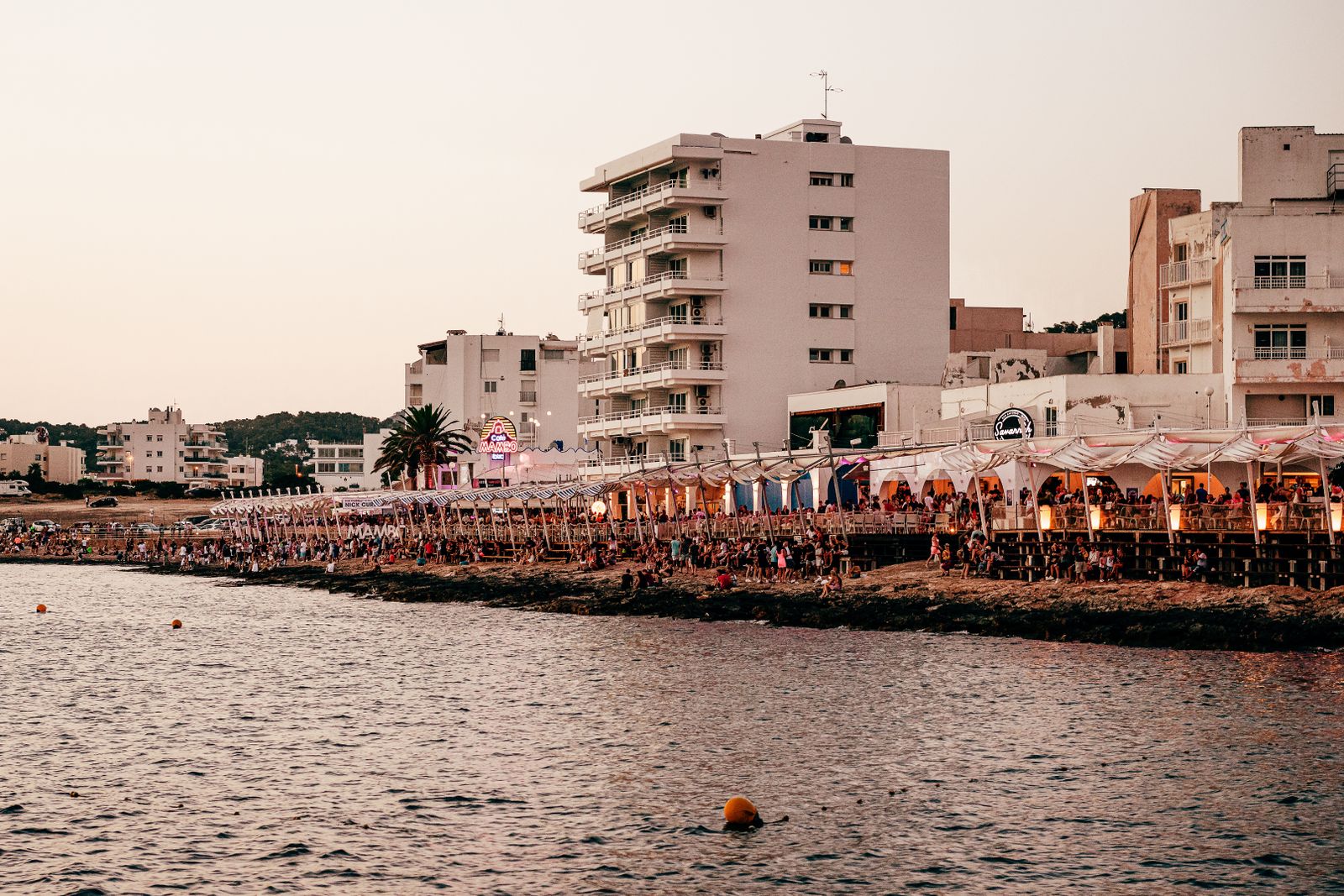 Lively Ibiza waterfront scene showcasing vibrant coastal nightlife at sunset.