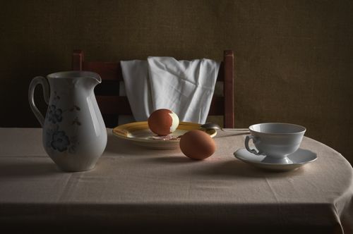 Free A classic still life featuring a jug, peeled eggs, and tableware on a table. Stock Photo