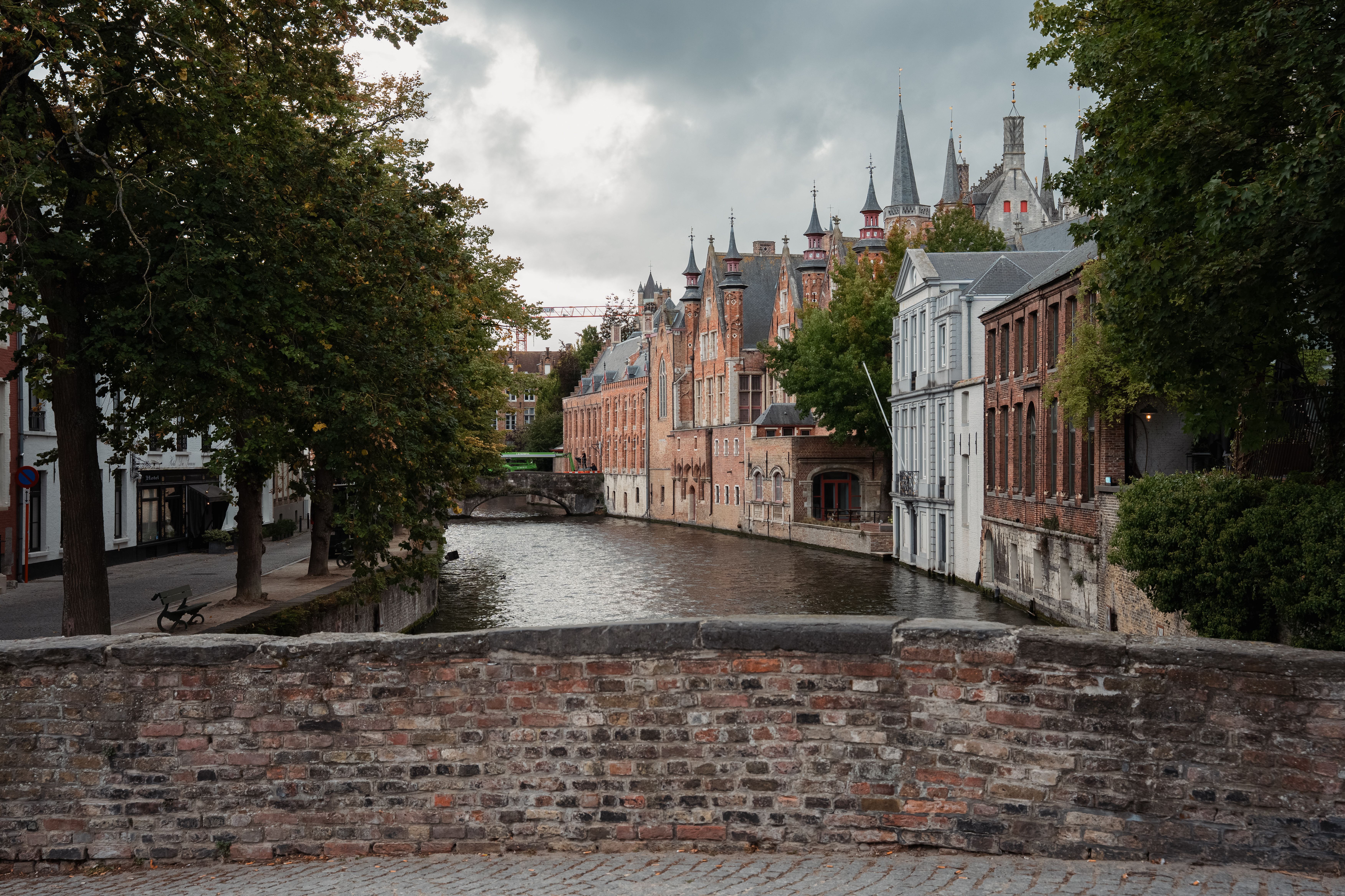 Beautiful view of Bruges canal with historic buildings and overcast sky, perfect for travel inspiration.