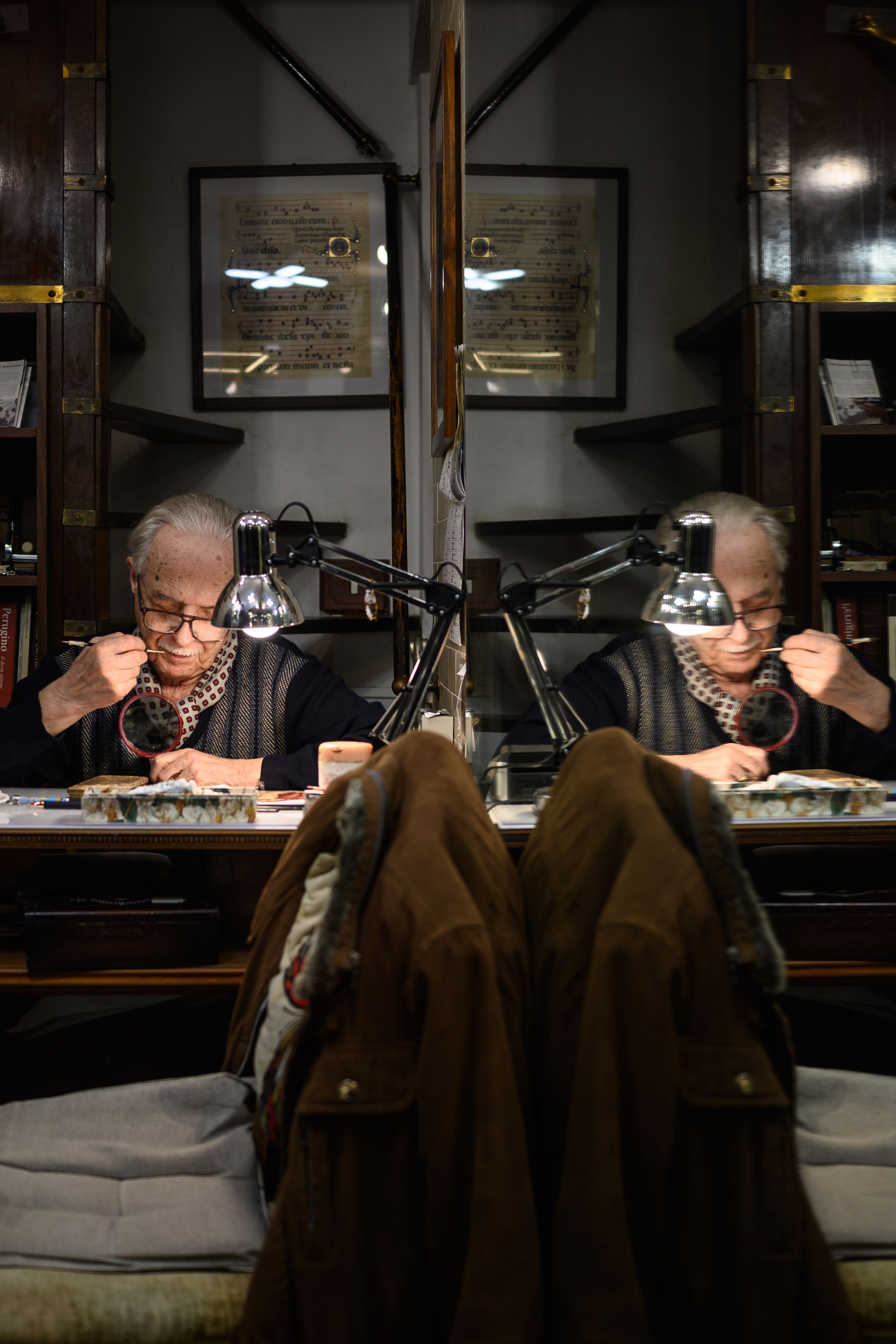 Elderly woman reading in a cozy study, surrounded by books and warm lighting, creating a reflective atmosphere.