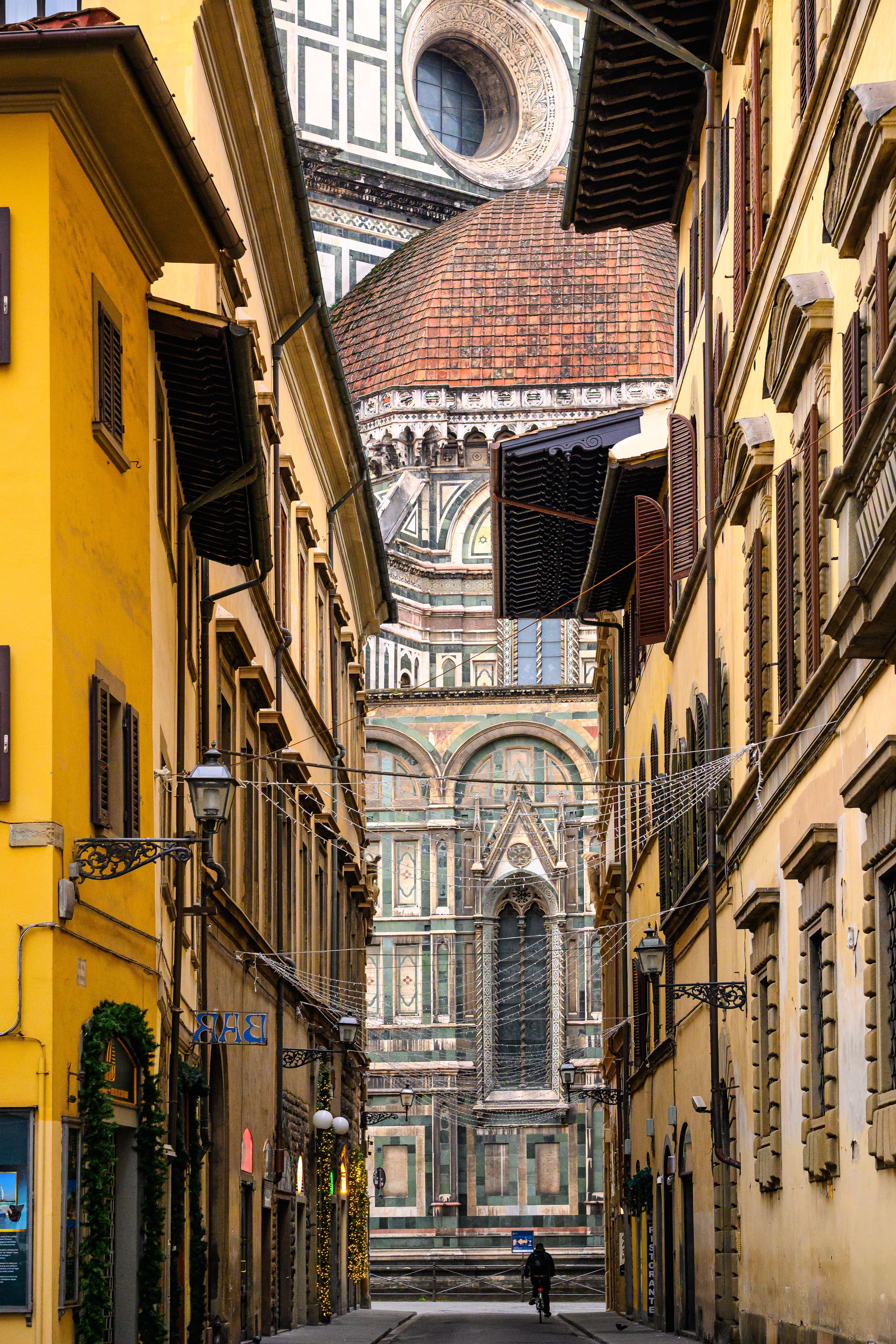 A breathtaking view of Florence Cathedral's dome seen through a narrow street in Florence, Italy.