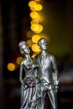 Close-up of a detailed wedding cake topper with artistic bokeh background, creating a dreamy atmosphere.