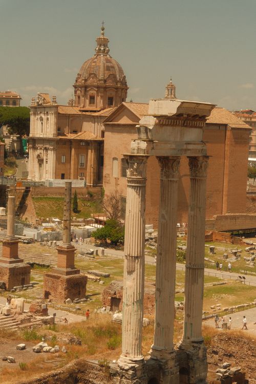 Free View of the Roman Forum showcasing historic temple ruins under a sunny sky. Stock Photo