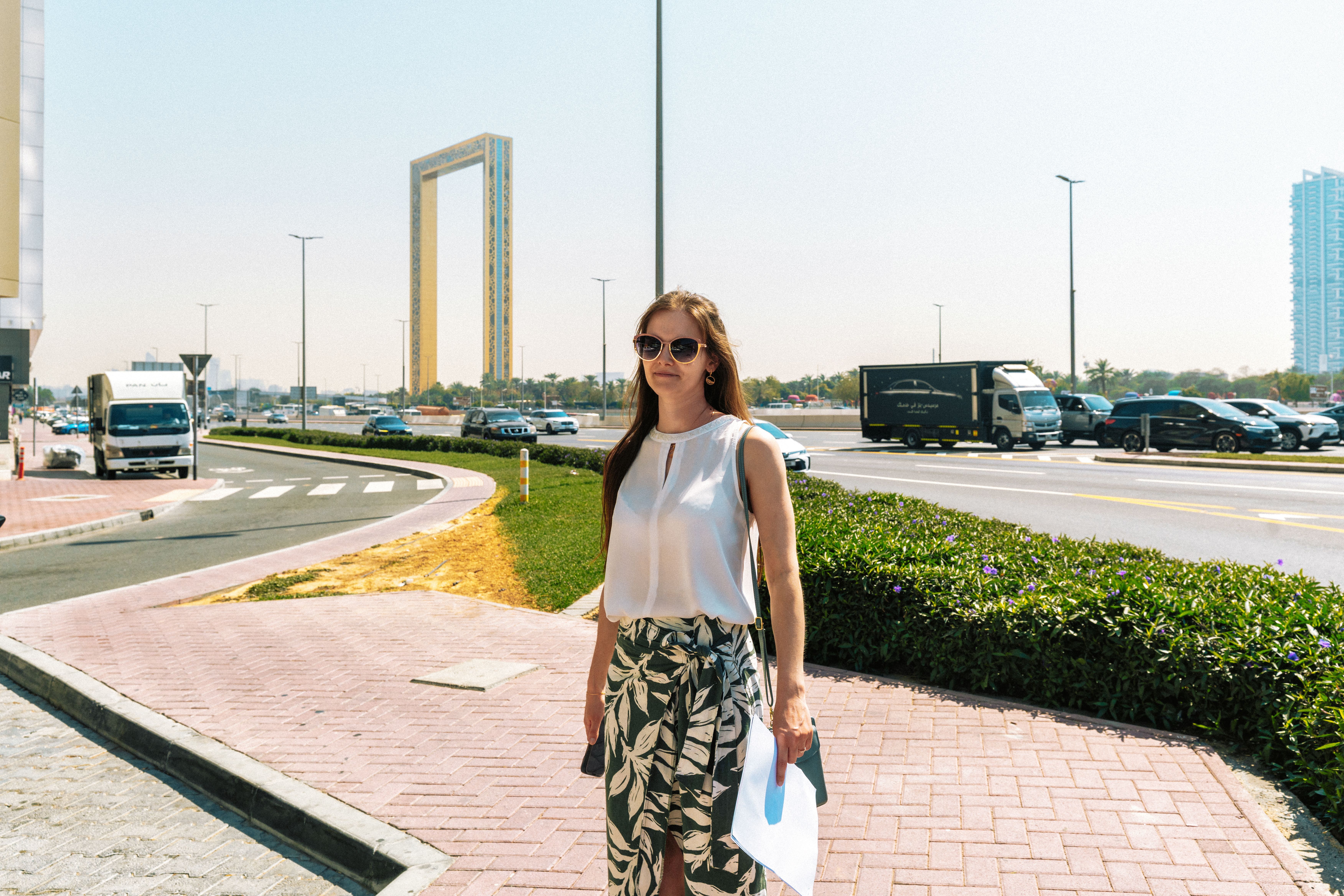 A woman enjoys a sunny day near the iconic Dubai Frame. Perfect for travel and lifestyle themes.