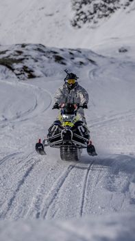 Thrilling snowmobile ride through snowy Madesimo landscape.