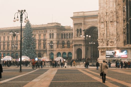 Festive atmosphere at Piazza Duomo, Milan, featuring Christmas tree and historic architecture.