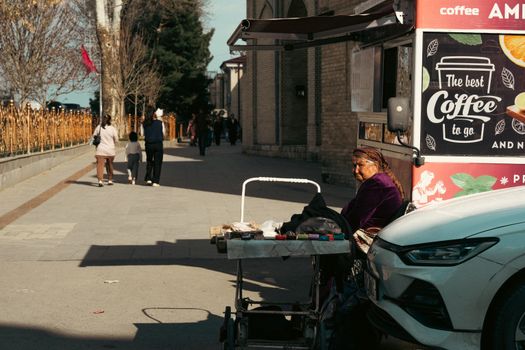 Street life in Uzbekistan featuring a local vendor by a coffee stand. Captivating cultural scene.