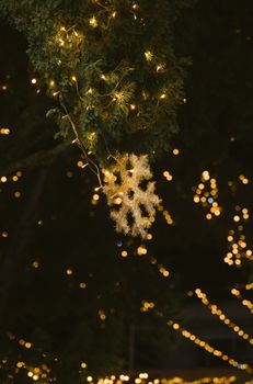 Close-up of holiday lights and snowflake decoration at night, evoking a festive and warm ambiance.
