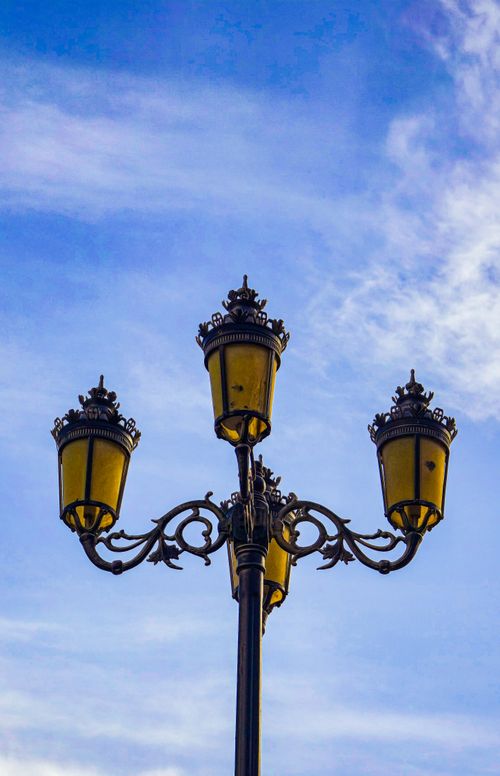 Free Elegant vintage street lamp with ornate design against a clear blue sky, perfect for outdoor decor themes. Stock Photo