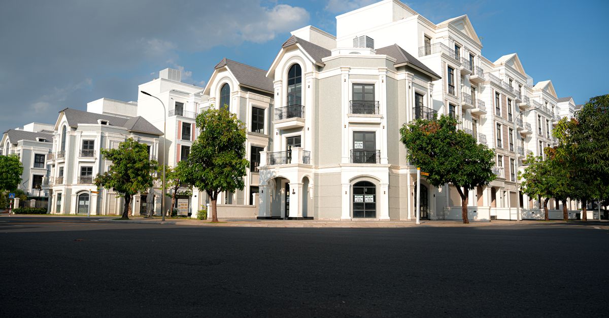 A modern apartment complex with classic architectural design under a bright blue sky.