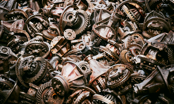 A dense pile of rusty mechanical gears and parts, creating an industrial texture.