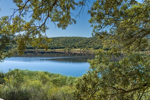 Free Tranquil lake scene in Ruidera, Spain with lush greenery and clear blue sky. Stock Photo