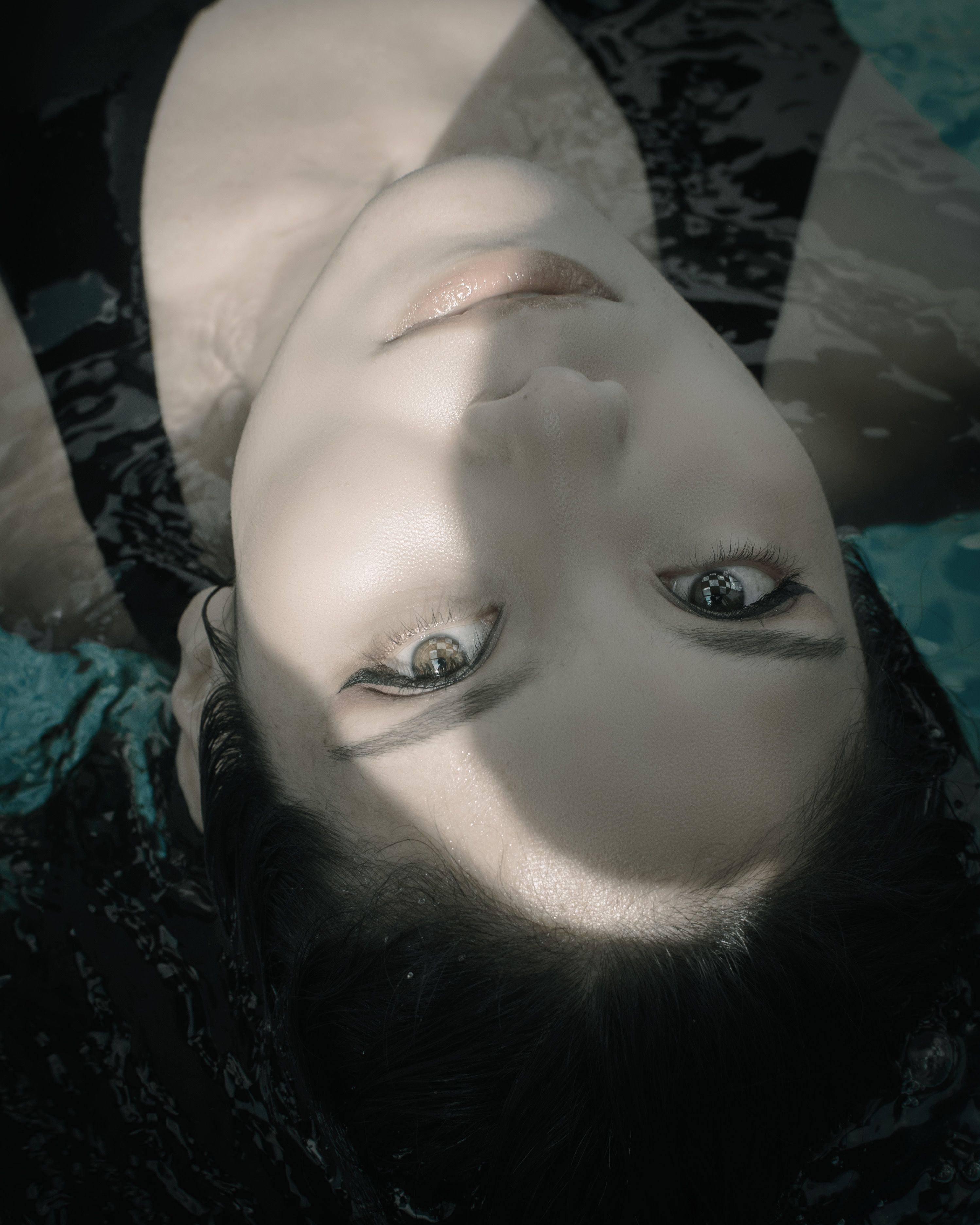 Serene close-up of a woman floating on water reflecting calmness.