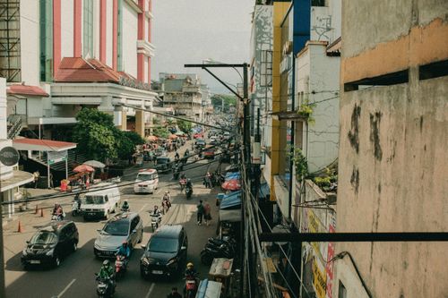 Free Lively city street with busy traffic and pedestrians in an urban area. Stock Photo