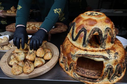 Free Close-up of artisan breads and pastries with intricate designs at a food market booth, showcasing craftsmanship. Stock Photo