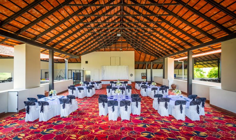 Spacious indoor venue adorned with round tables and elegant decor, perfect for weddings or conferences