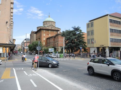 Free Busy urban street scene with cyclist and historic dome building under blue sky. Stock Photo