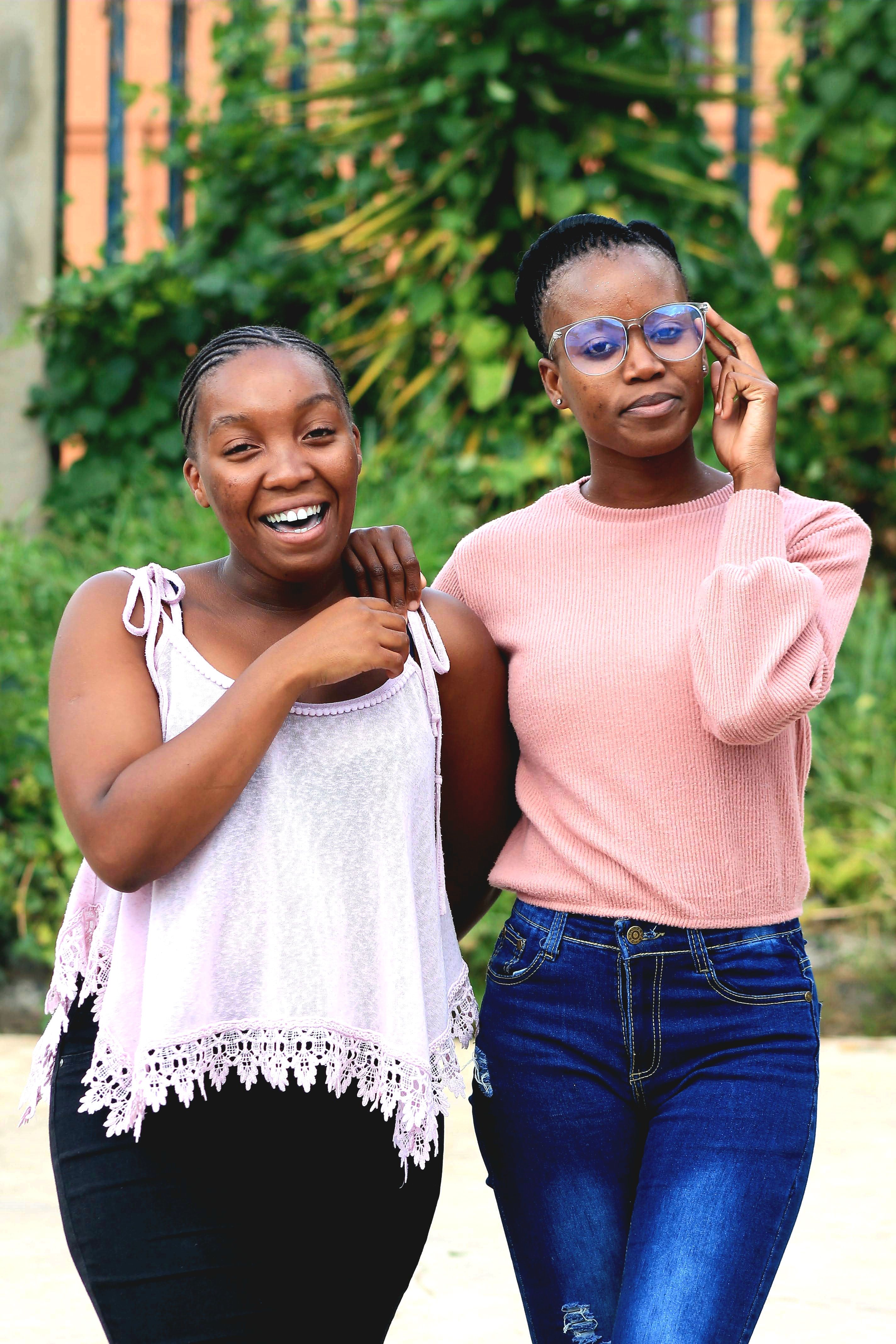 Two Women Smiling Outdoors in Casual Attire · Free Stock Photo