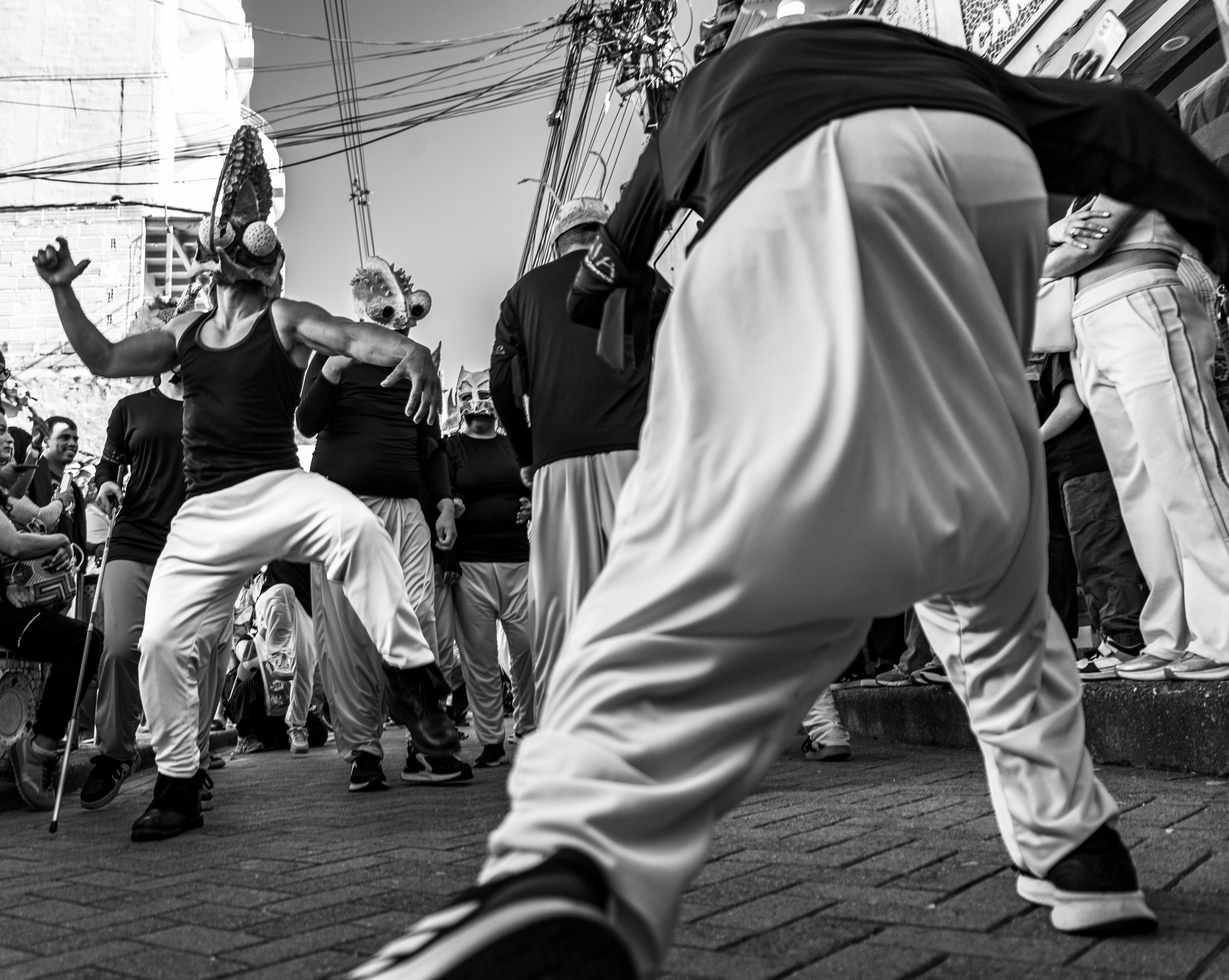 Dynamic black and white photo of a lively street dance performance during a cultural festival.