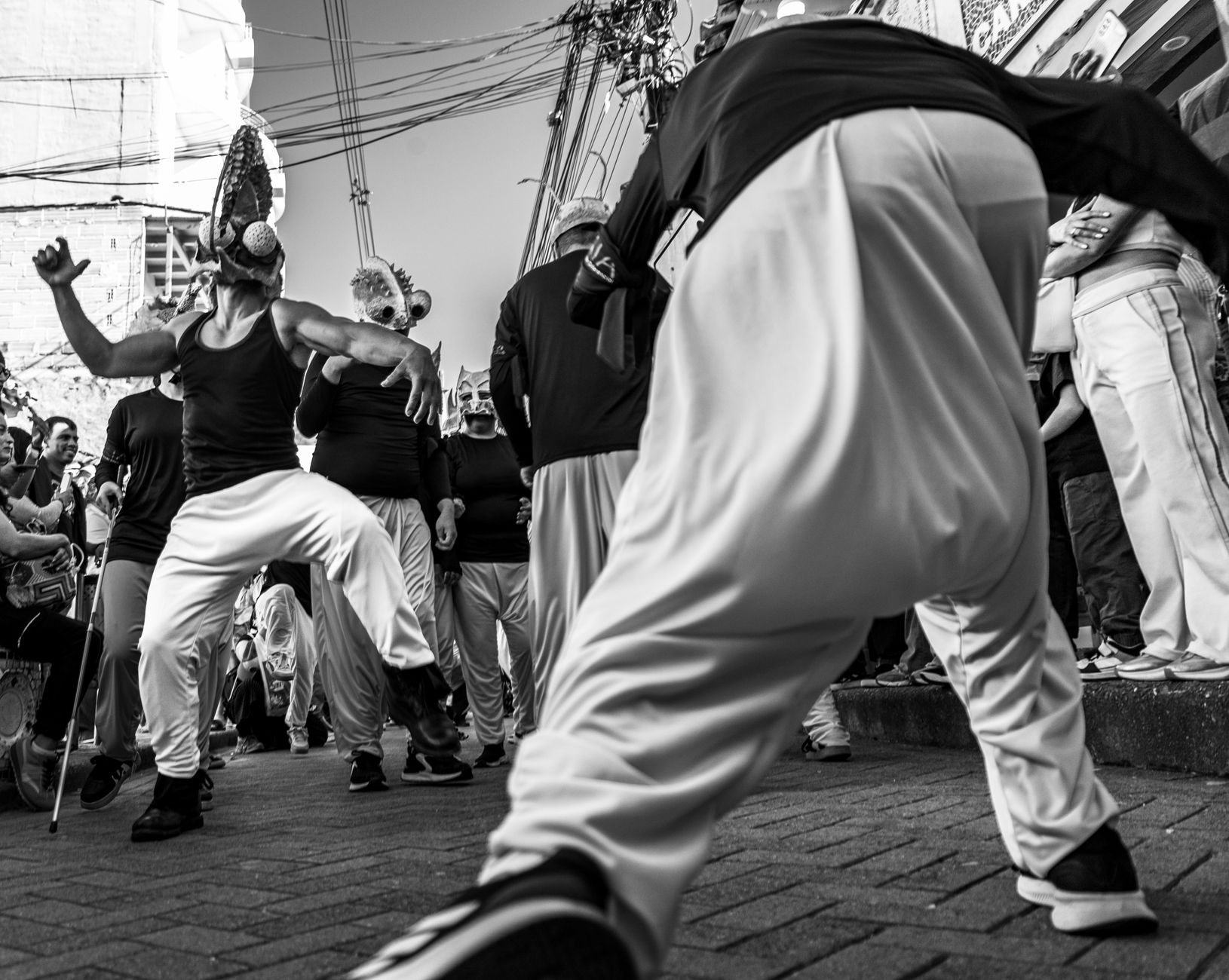 Dynamic black and white photo of a lively street dance performance during a cultural festival.