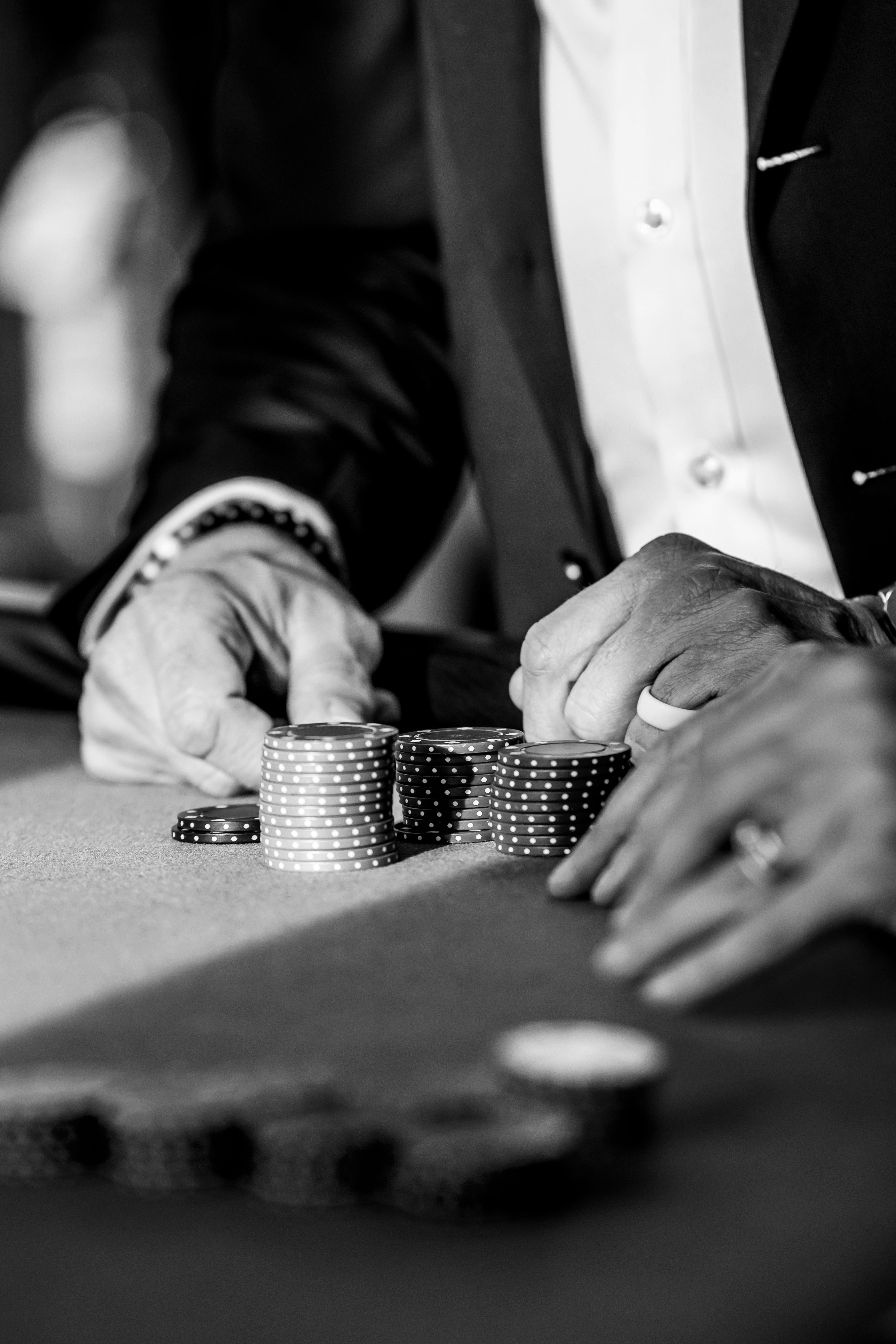 grátis Homem elegante jogando pôquer em uma mesa de cassino, empilhando fichas em um ambiente sofisticado. Foto profissional