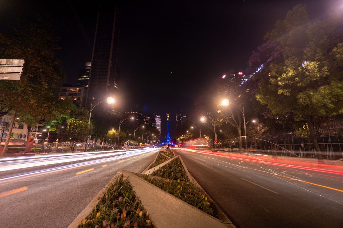 Captivating night scene of bustling traffic and the Angel of Independence on Paseo de la Reforma, CDMX.