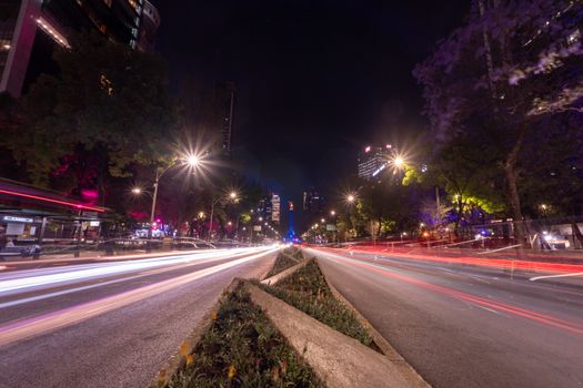 Dynamic long exposure of city traffic at night with colorful lighting in Mexico City.