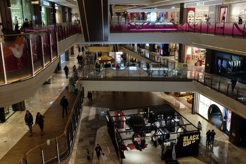 Free Spacious indoor mall with elegant design, featuring various shops and escalators. Stock Photo