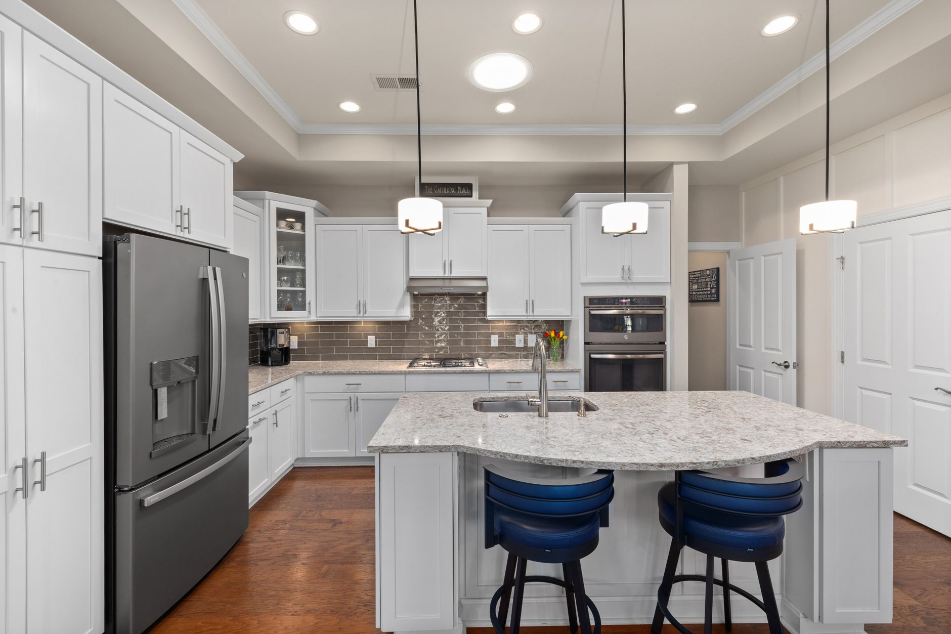 Elegant white kitchen renovation in Guelph featuring a marble island and stainless steel appliances. Elegant white kitchen renovation in Guelph featuring a marble island and stainless steel appliances.