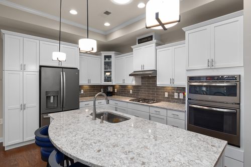 Free Stylish modern kitchen featuring a large island, granite countertops, and stainless steel appliances. Stock Photo