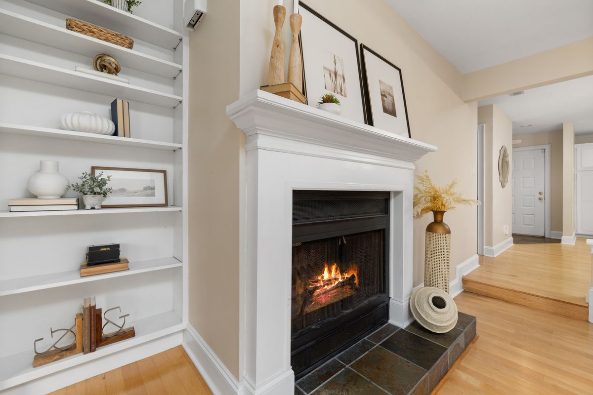 Elegant living room interior featuring a lit fireplace and decorative shelving. Stock Photo.
