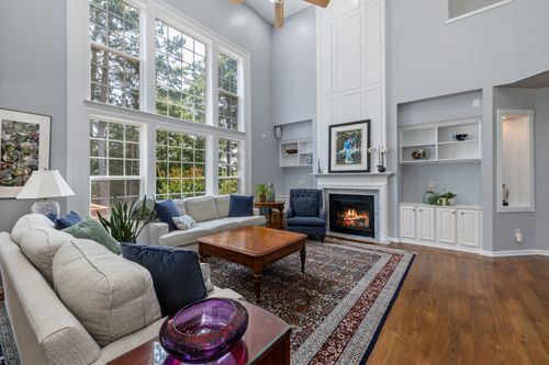 Free Bright living room with large windows, fireplace, and elegant decor. Stock Photo