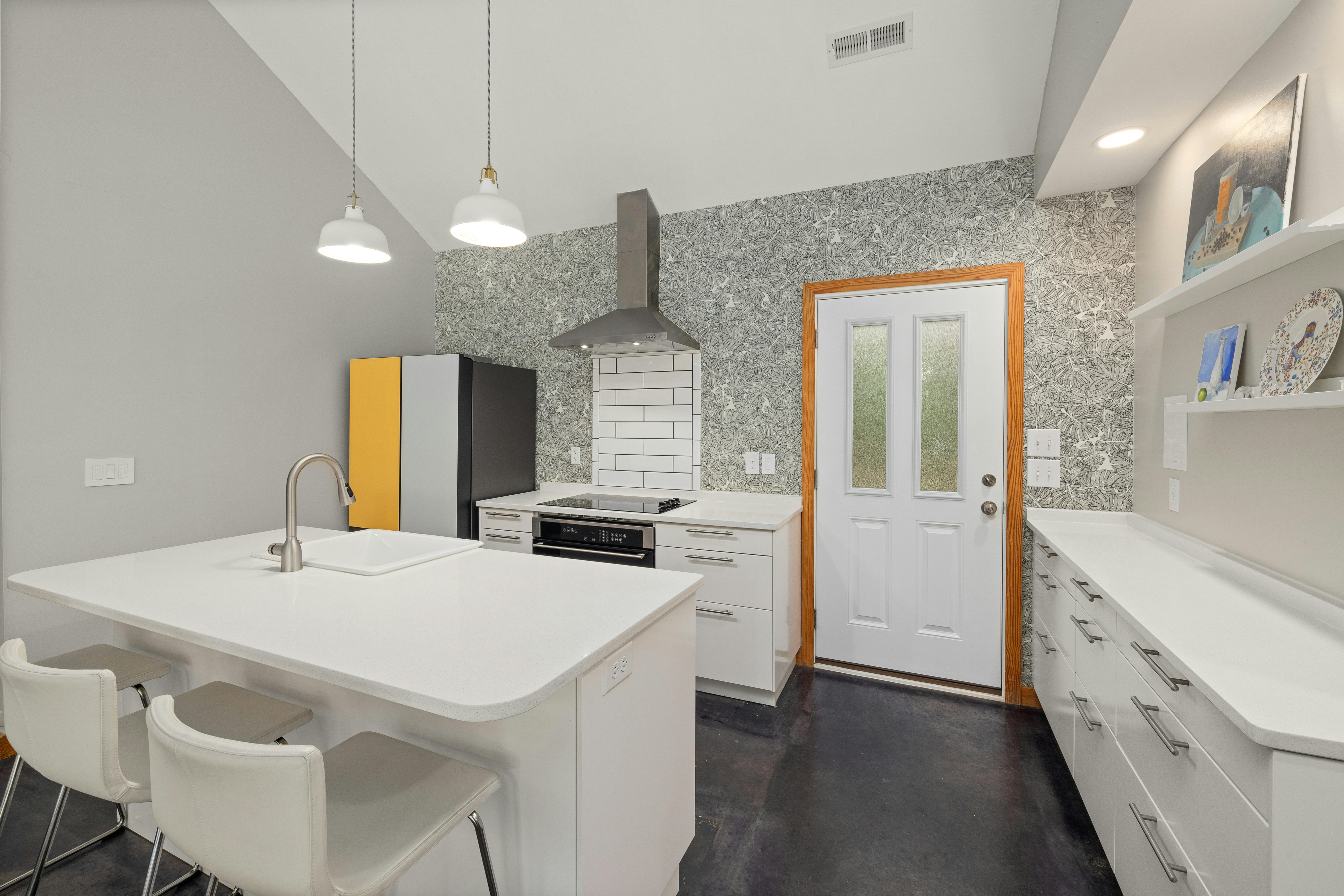 Sleek and modern minimalist kitchen featuring a central island and contemporary decor.