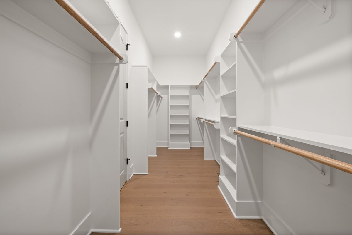 Spacious walk-in closet with organized shelving — home storage market target