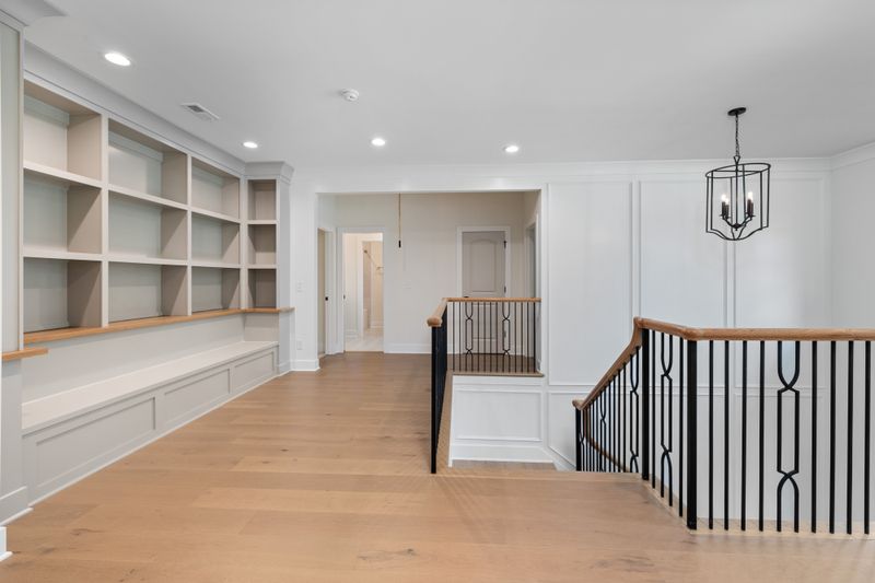 Entry foyer with staircase — framing the continuous limestone floor plane at threshold