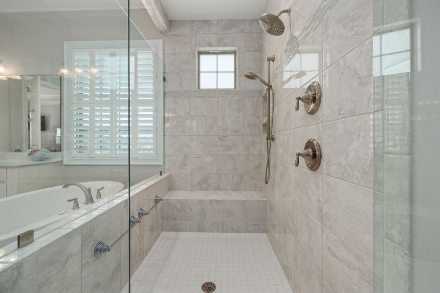 Modern bathroom shower with white tiles and glass enclosure
