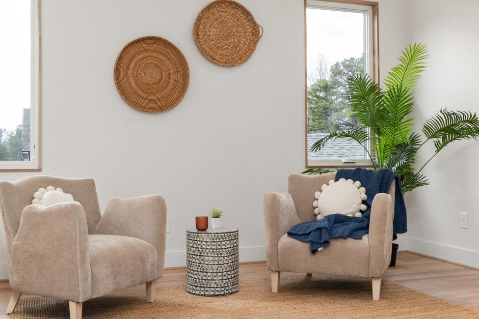 Helles Wohnzimmer im skandinavischen Stil mit Sessel, Sofa und kleinem Beistelltisch