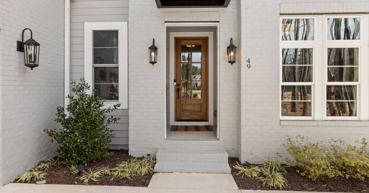 Stylish modern front entrance with wooden door and exterior lighting features.