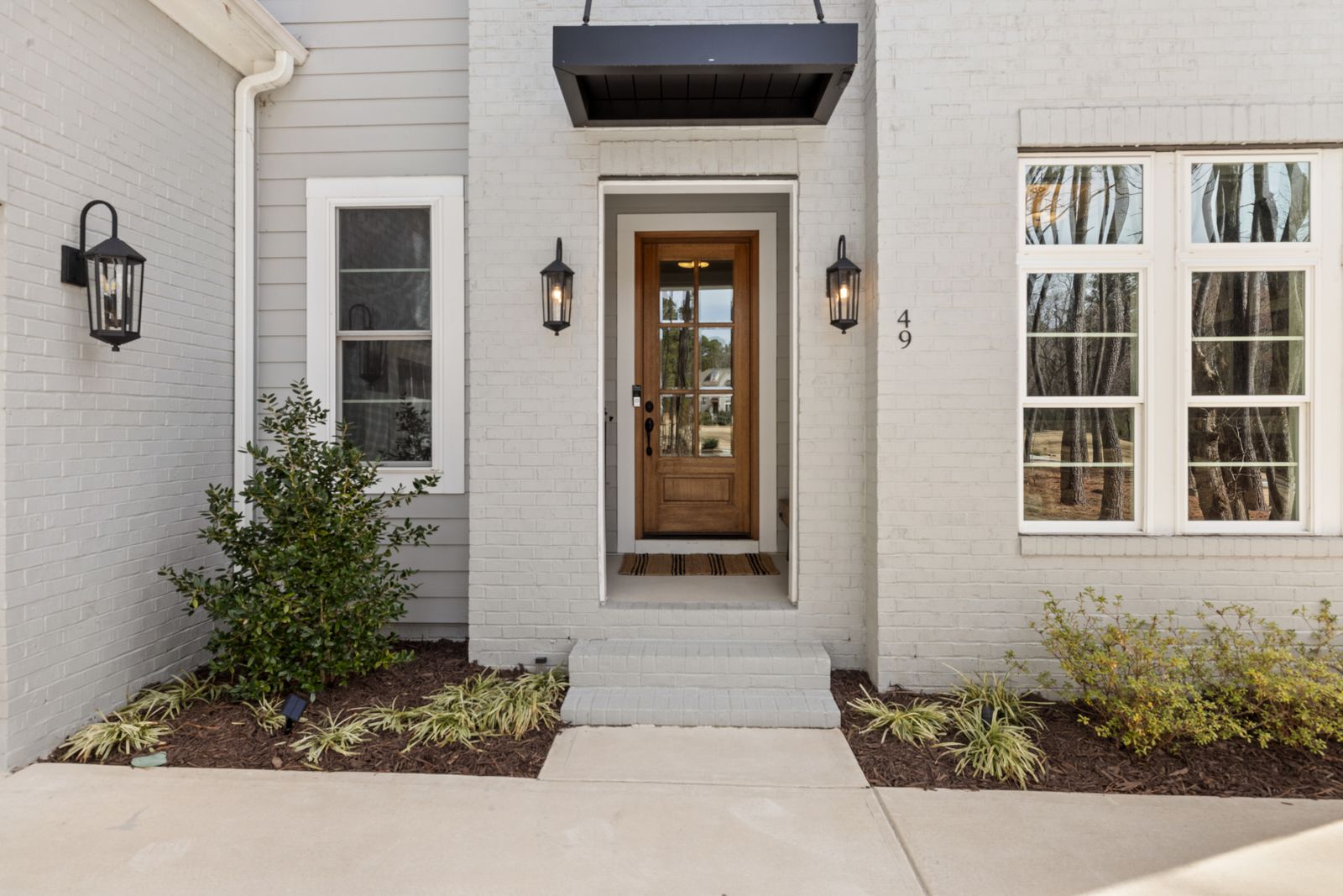 Modern home front entrance with a wooden door, clean architectural lines, and exterior lighting, Edgewood, Naperville IL
