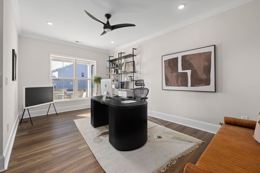 Stylish modern home office with a sleek desk, artwork, and ample natural light.