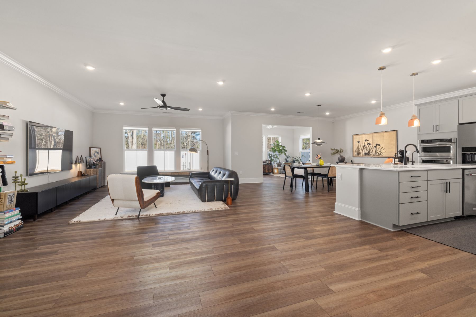 Bright open-concept living room with clear surfaces and minimal seasonal visual weight