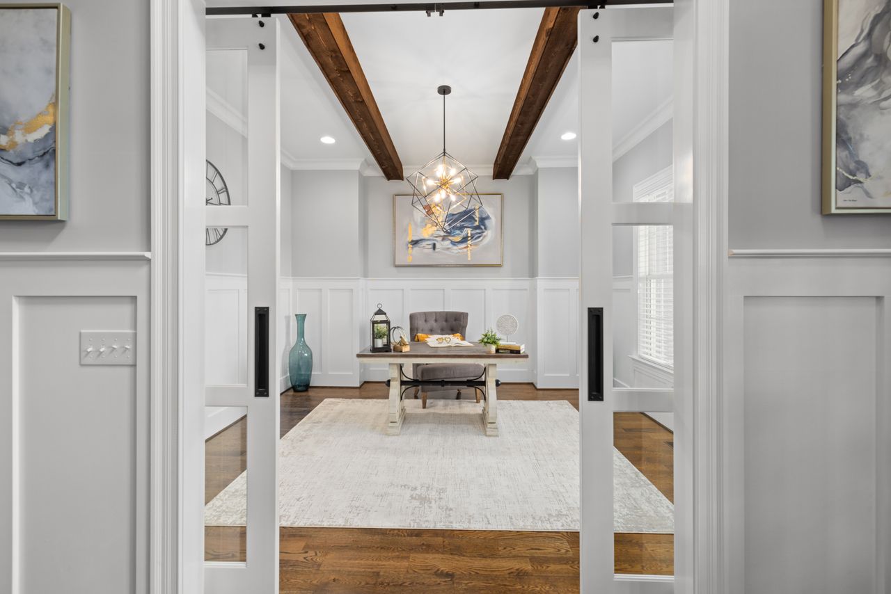 White sliding barn-style double doors with glass panels leading into a home office