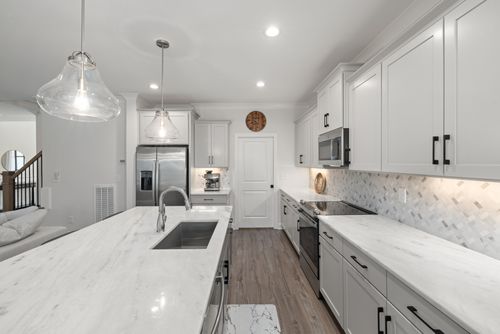 Free Elegant modern kitchen with marble countertops, stainless steel appliances, and pendant lighting. Stock Photo