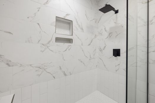 Sleek bathroom shower featuring marble tiles and black fixtures, perfect for modern luxury home design.