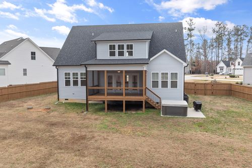 Free Two-story suburban home with wooden deck and fenced backyard, ideal for family living. Stock Photo