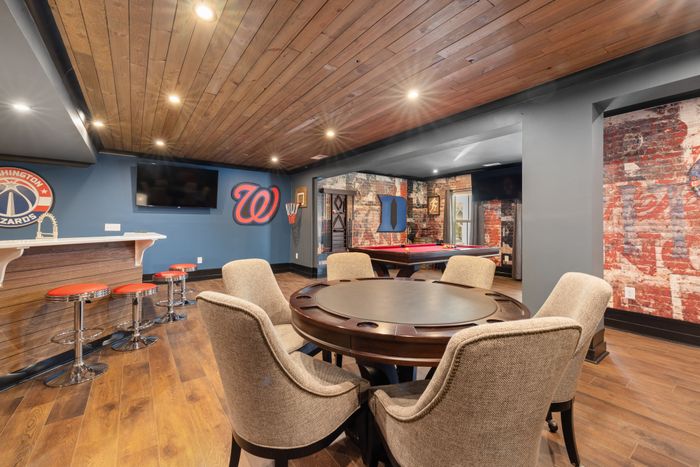 Modern basement game room with bar and pool table