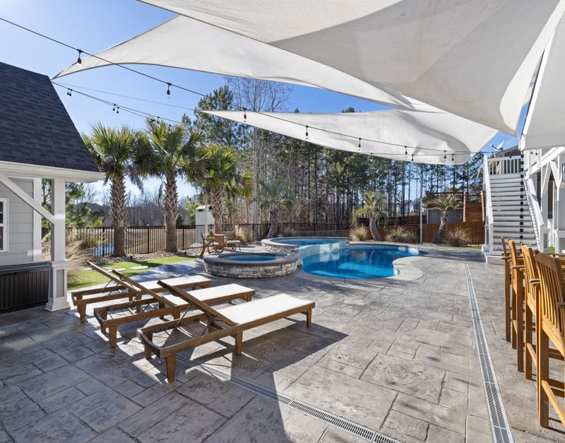 Outdoor pool area with lounge chairs and palm trees