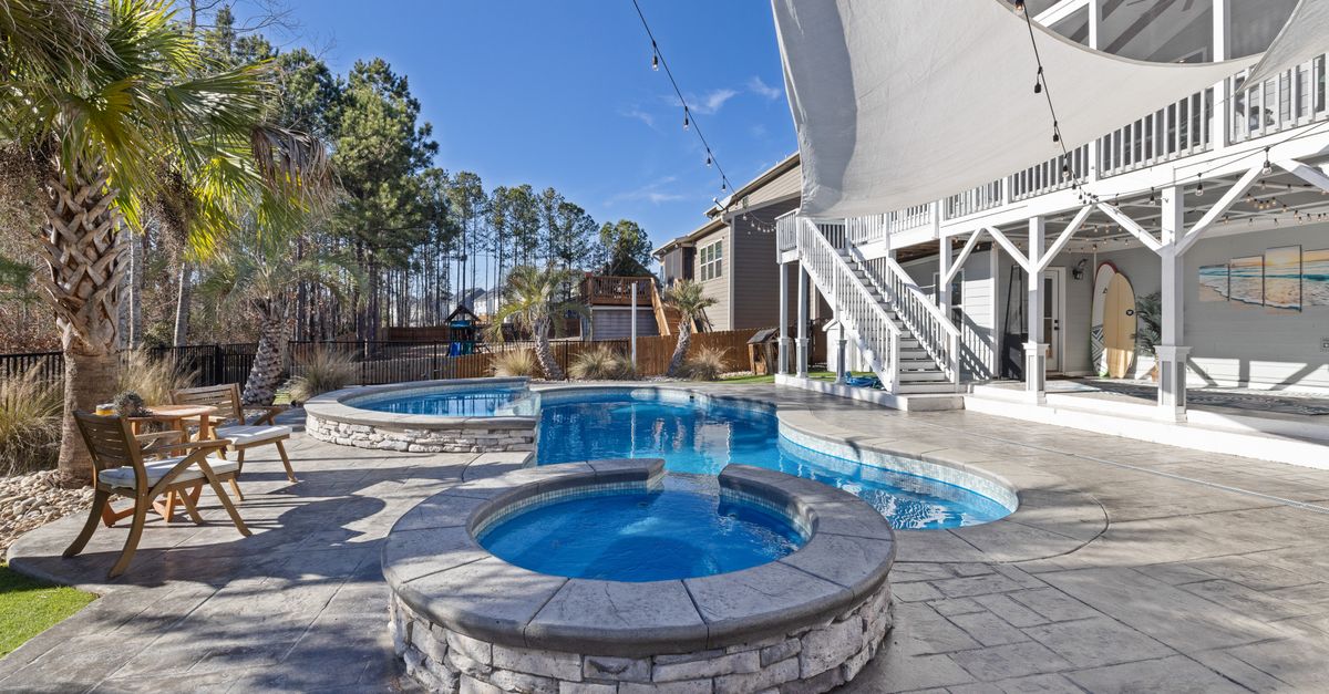 Stunning outdoor pool area with modern amenities, surrounded by palm trees and elegant decking.