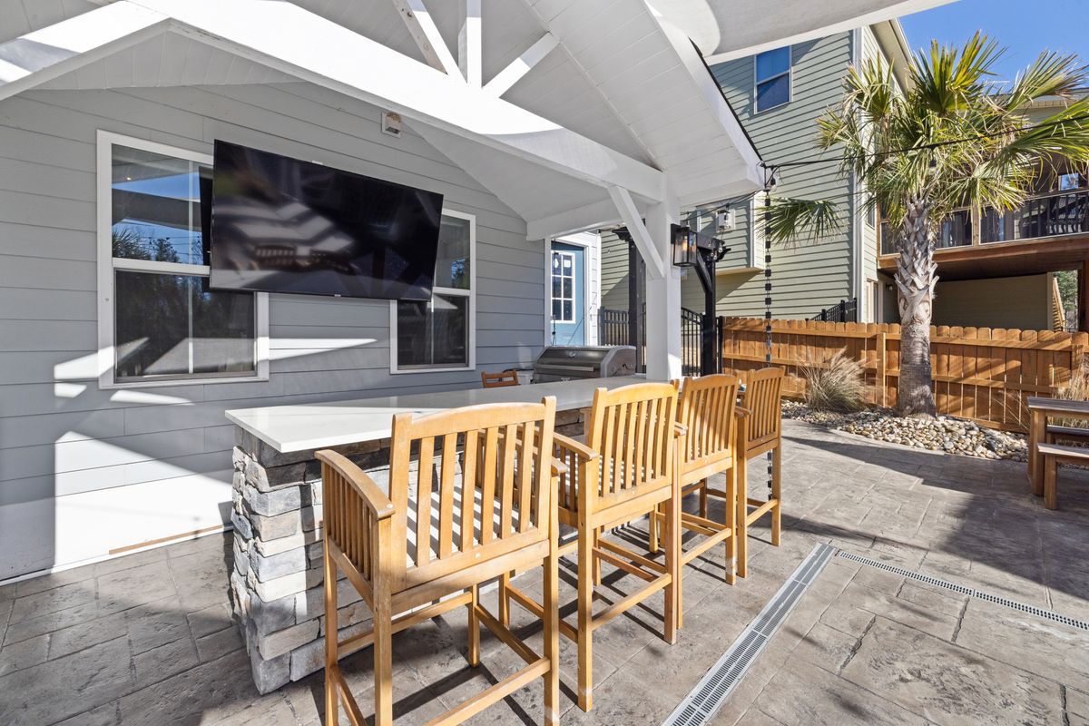 Überdachte Terrasse mit stabilem Holzdach, Essbereich mit Bartisch und Loungemöbeln direkt am Haus