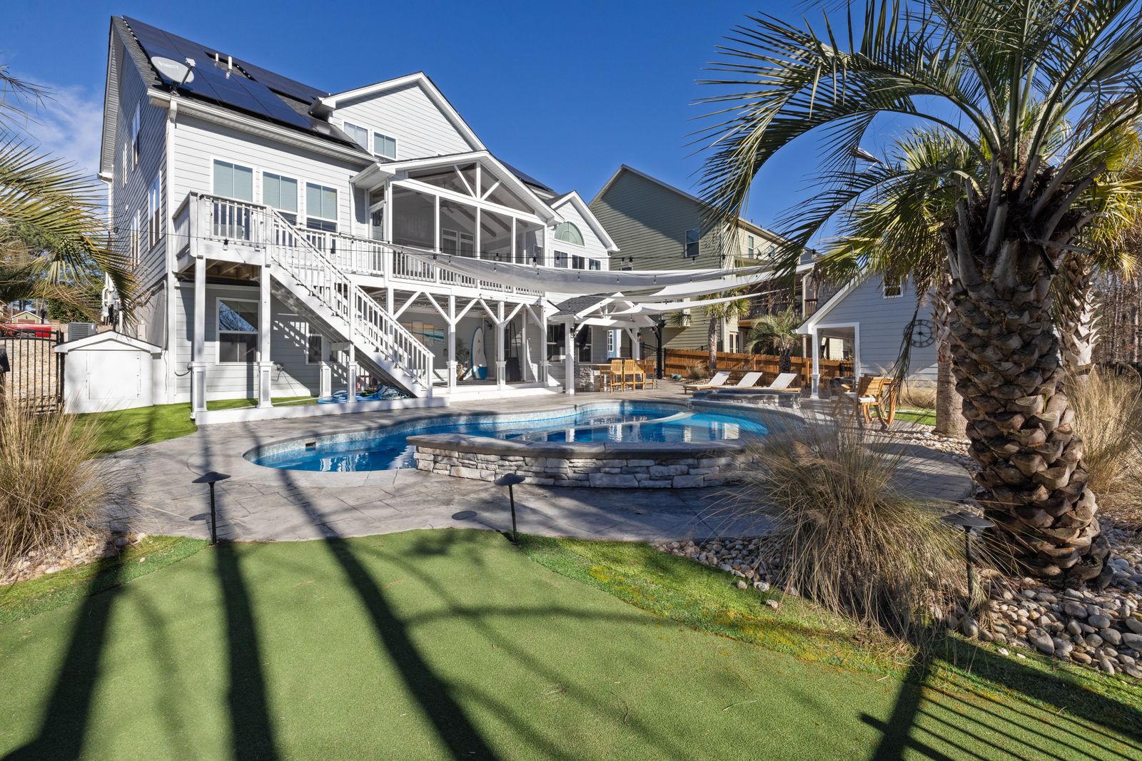 Modern coastal home with pool and palm trees